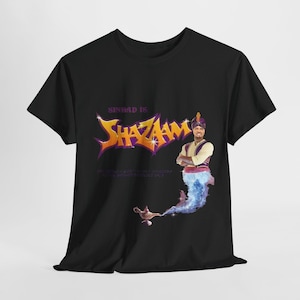May include: Black t-shirt with a graphic of a man in a genie costume with the text "Sinbad is Shazaam!" printed on it.