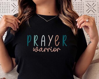 May include: A black t-shirt with the text "PRAYER warrior" in colorful lettering.