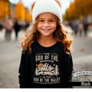 May include: Black long-sleeve sweatshirt with a vintage-style graphic print that reads "The God of the Mountain is the God of the Valley". The graphic features a mountain range, a bear, and trees. The text is in a brown font.