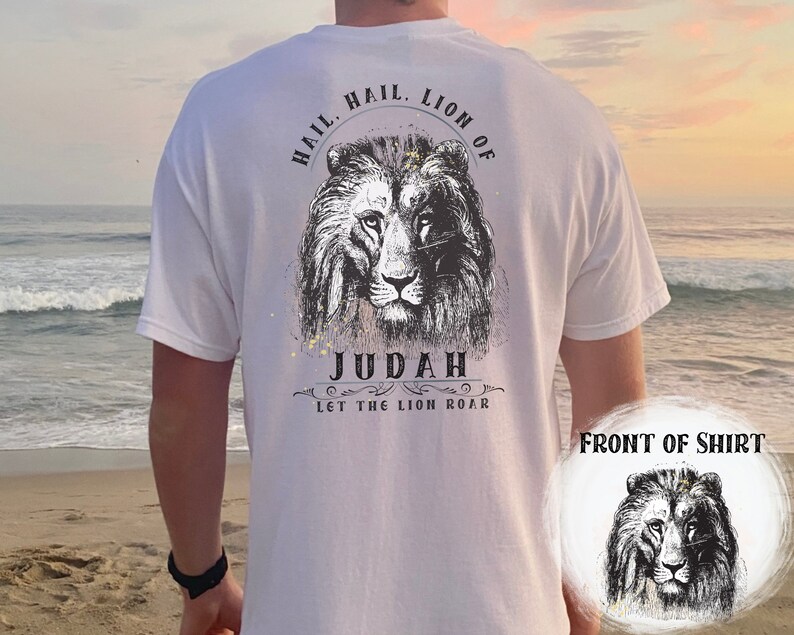 Może przedstawiać: Biała koszulka z czarno-białym nadrukiem lwa z tyłu. Nadruk zawiera tekst "Hail, Lion of Judah, Let the Lion Roar".