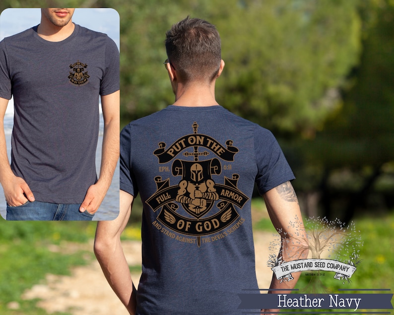 May include: Heather navy blue t-shirt with a gold graphic of a knight in armor with the text "Put on the Full Armor of God and Stand Against the Devil's Schemes" and the text "The Mustard Seed Company" at the bottom.
