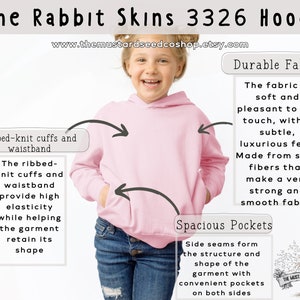 Puede incluir: Sudadera con capucha rosa con pu&ntilde;os y cintura de canal&eacute;. La tela es suave y c&oacute;moda. La sudadera tiene bolsillos espaciosos en ambos lados. El texto "The Rabbit Skins 3326 Hoodie" y "www.themustardseedcoshop.etsy.com" est&aacute; impreso en la imagen.