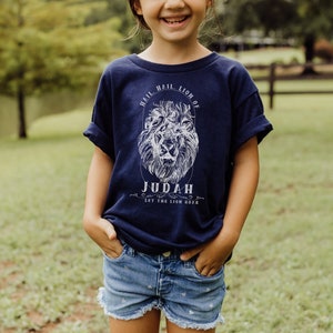 May include: A navy blue t-shirt with a white lion graphic and the text "Hail, Hail, Lion of Judah, Let the Lion Roar".