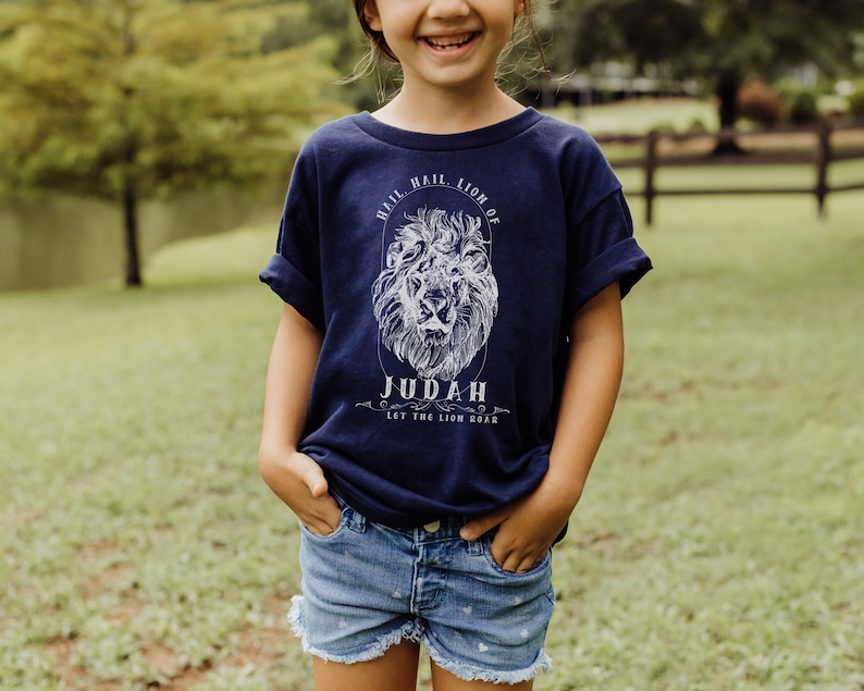 May include: A navy blue t-shirt with a white lion graphic and the text "Hail, Hail, Lion of Judah, Let the Lion Roar".