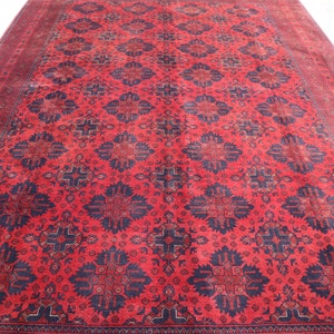 May include: A red and blue rug with a traditional Persian design. The rug has a geometric pattern with intricate details.