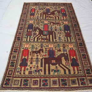 May include: Rectangular beige rug featuring a repeating pattern of figures on horseback and standing figures in red and blue attire. The rug has a detailed border with geometric shapes and floral motifs, and is likely hand-woven.
