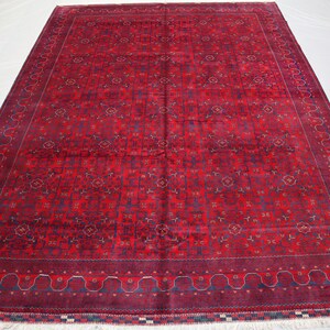 May include: A red and blue patterned rug with a detailed border. The rug has a traditional design and is made of wool.