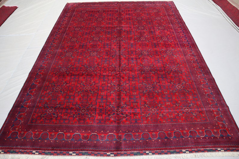 May include: A red and blue patterned rug with a detailed border. The rug has a traditional design and is made of wool.