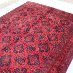 May include: A red and black patterned rug with a traditional design. The rug has a dark border and a central medallion.