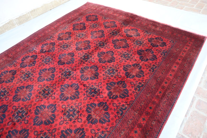 May include: A red and black patterned rug with a traditional design. The rug has a dark border and a central medallion.