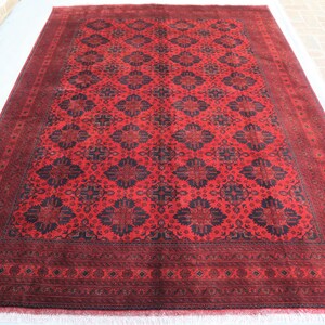 May include: A red and black rug with a traditional Persian design. The rug has a detailed border and a central medallion.