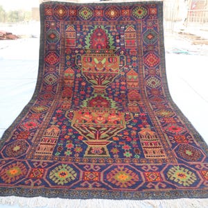 Può includere: Un tappeto persiano tradizionale con sfondo blu scuro e intricati motivi floreali e geometrici in tonalità di rosso, verde, giallo e arancione. Il tappeto ha un bordo a frange.