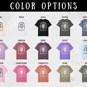 Peut inclure: Plusieurs t-shirts de diff&eacute;rentes couleurs, chacun avec le texte "DEAD TIRED MOMS CLUB" et un motif de cr&acirc;ne. Les options de couleurs incluent ivoire, blanc, noir, poivre, bleu jean, orchid&eacute;e, cramoisi, baie, violet et plus.