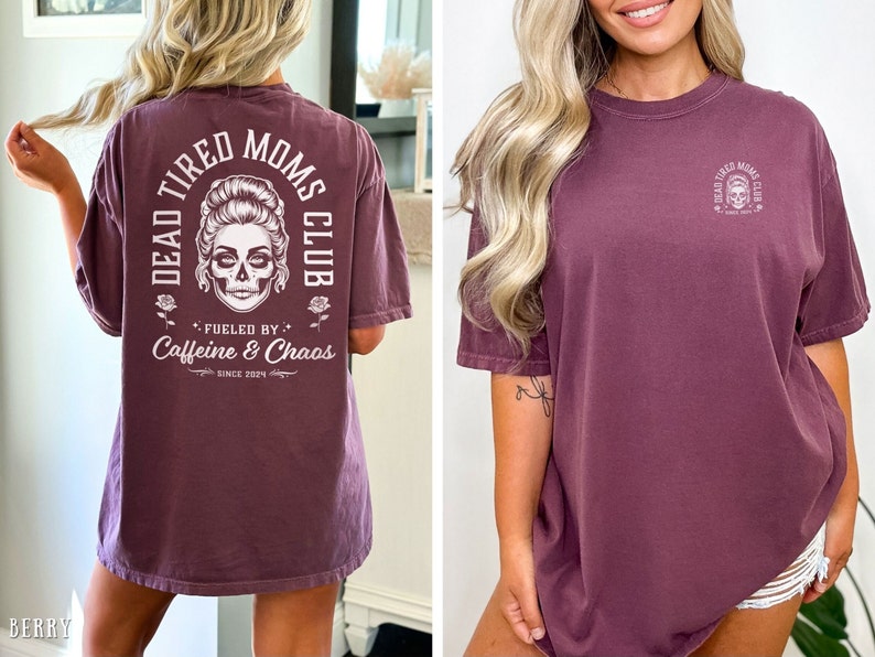 Peut inclure: T-shirt de couleur baie avec l'inscription "DEAD TIRED MOMS CLUB" et un motif de cr&acirc;ne. Le dos du t-shirt porte l'inscription "Fueled by Caffeine & Chaos Since 2024". Le devant du t-shirt pr&eacute;sente une version plus petite du motif de cr&acirc;ne.