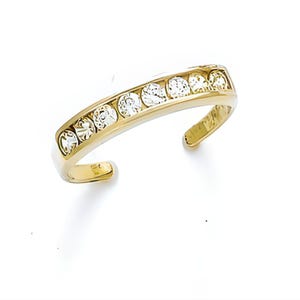 May include: A gold-toned toe ring featuring a row of clear, sparkling gemstones. The open design allows for an adjustable fit. The ring is set against a white background, highlighting the jewelry's details.
