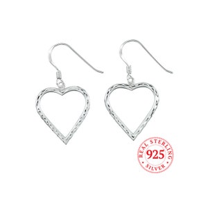 May include: Sterling silver heart shaped dangle earrings with a diamond pattern. The earrings are on a white background with a red stamp that says "REAL STERLING 925 SILVER".