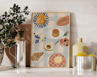 May include: A framed print with a colorful illustration of breakfast foods, including fruit, pastries, and a glass of juice. The print is on a white background with a light blue and pink checkered pattern. The print is hanging on a wall with a light beige texture.