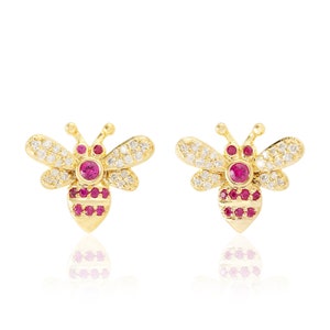 Op de afbeelding: Gouden bijen oorbel studs met heldere en roze zirkonia stenen.