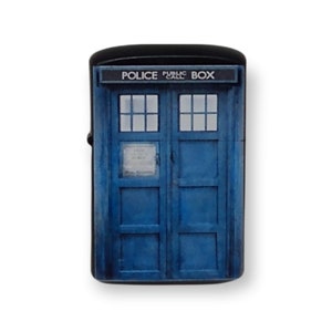 May include: A black lighter with a blue and white image of a police call box. The box has the text "POLICE PUBLIC CALL BOX" on the top.
