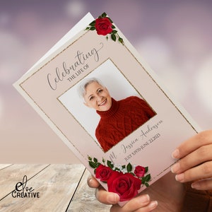 May include: A pink and gold funeral program with a photo of a woman and the text "Celebrating the Life of M. Jessica Anderson July 5, 1970-June 22, 2023". The program is decorated with red roses and green leaves.