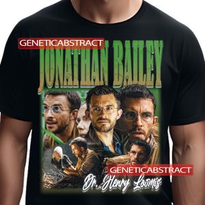 May include: Black t-shirt featuring a collage of images of Jonathan Bailey, with the text "JONATHAN BAILEY" in green and "Dr. Henry Loomis" in white. The shirt also has the text "GENETICABSTRACT" in red.