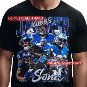 May include: Black t-shirt featuring a collage of football players in blue and black uniforms. The design includes the name "Jahmyr Gibbs" in blue, along with the word "Lions" and the number "26". The text "Sonic" is also present.