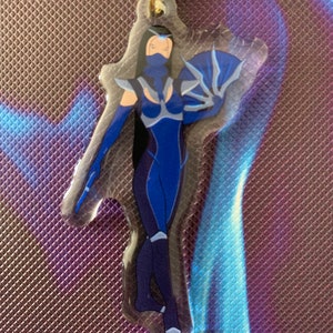 May include: A blue and white character with a fan, printed on a clear acrylic keychain with a gold metal ring.