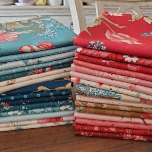 May include: A collection of folded fabric stacks, each displaying different floral patterns. The colour palette includes teal, red, pink, and navy. The floral designs feature roses and other botanical elements. The fabrics are neatly stacked, showcasing the variety of patterns.