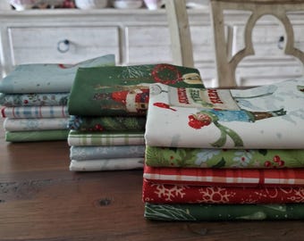 Pode incluir: Pilhas de tecidos com temas natalinos em vários padrões e cores. Os desenhos incluem o Papai Noel, flocos de neve e cenas de inverno. Os tecidos são dobrados e dispostos sobre uma superfície de madeira.
