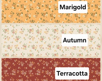 May include: Three horizontal fabric swatches featuring a repeating floral pattern with small white and orange flowers on dotted backgrounds. The top swatch is labeled Marigold, the middle swatch is labeled Autumn, and the bottom swatch is labeled Terracotta.