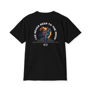 May include: Black t-shirt with a graphic on the back featuring an astronaut riding a motorcycle engulfed in flames. The text "I'VE NEVER BEEN TO THE MOON" is arched above the image. A grid and two globe icons are below the image.