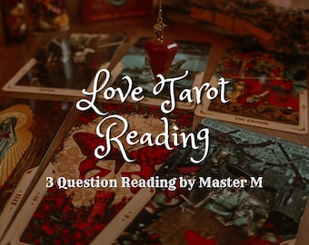 May include: A close-up of a tarot card reading spread with the text "Love Tarot Reading 3 Question Reading by Master M". The cards are on a wooden table with a red pendulum hanging above.