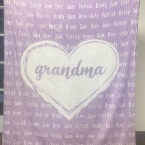 May include: A purple fleece blanket with the word "grandma" in a white heart shape. The blanket is covered in a repeating pattern of names, including "Jake", "Patrick", "Brody", "Sam", and "Bree".