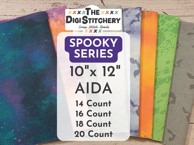 May include: A collection of AIDA cross-stitch fabric pieces in various colors and patterns, including a galaxy print and bat silhouettes. The label reads "SPOOKY SERIES" and lists sizes as 10" x 12" (25.4 cm x 30.5 cm) with different thread counts.