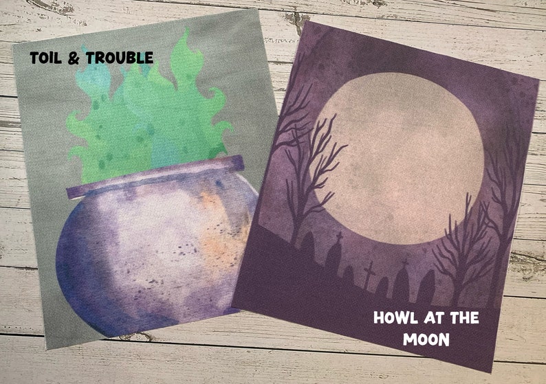 May include: Two Halloween-themed prints. One features a purple cauldron with green smoke and the text "TOIL & TROUBLE." The other depicts a full moon, bare trees, and tombstones with the text "HOWL AT THE MOON."