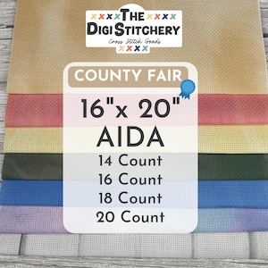May include: A stack of AIDA cross-stitch fabric in various colors, including tan, red, yellow, green, blue, and lavender. The label reads "COUNTY FAIR" and specifies sizes of 16" x 20" and different thread counts.