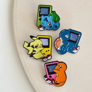 Pin / Emaille Brosche / Anstecker von Pokémon - Gameboy Advance - Shiggy - Pikachu - Bisasam - Glumanda