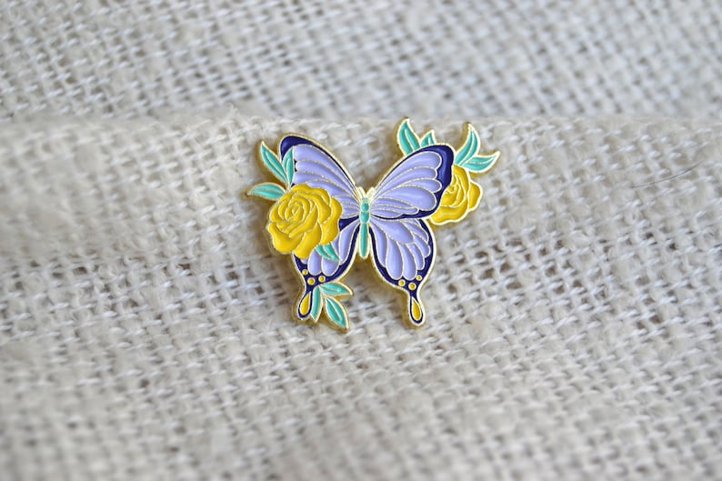 Pin / Brosche / Emaille Anstecker in Form von Schmetterlingen mit verschiedenen Blumen und Blüten Lila