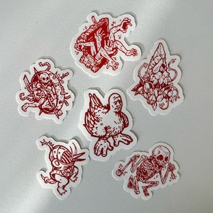 Puede incluir: Un conjunto de seis pegatinas rojas y blancas con ilustraciones únicas. Los diseños incluyen una figura con múltiples brazos, un esqueleto, un híbrido pollo-humano y otras imágenes abstractas. Las pegatinas están troqueladas con un borde blanco.