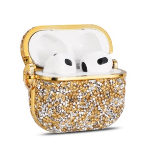 May include: A gold and white sparkly case for AirPods. The case has a gold trim and is covered in small rhinestones.