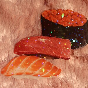 Peut inclure: Trois pi&egrave;ces de sushi avec diff&eacute;rentes garnitures. La premi&egrave;re pi&egrave;ce est un nigiri avec une garniture de poisson rouge. La deuxi&egrave;me pi&egrave;ce est un nigiri avec une garniture de viande rouge. La troisi&egrave;me pi&egrave;ce est un maki avec une garniture de caviar rouge.