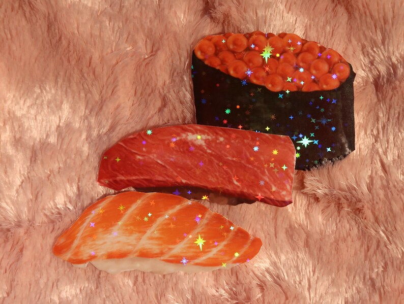 Peut inclure: Trois pi&egrave;ces de sushi avec diff&eacute;rentes garnitures. La premi&egrave;re pi&egrave;ce est un nigiri avec une garniture de poisson rouge. La deuxi&egrave;me pi&egrave;ce est un nigiri avec une garniture de viande rouge. La troisi&egrave;me pi&egrave;ce est un maki avec une garniture de caviar rouge.