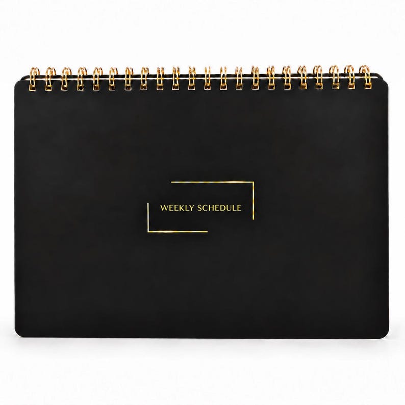 May include: A black weekly schedule planner with a gold wire spiral binding at the top. The front cover features the text WEEKLY SCHEDULE in gold lettering, enclosed within a thin gold rectangular frame design centered on the black surface.