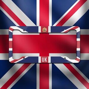 May include: License plate frame featuring the Union Jack flag design. The frame is white with red and blue accents, and the letters "UK" are visible at the bottom. The background is a blurred image of the Union Jack flag.