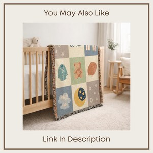 May include: A woven baby blanket with a patchwork design featuring a teddy bear, moon, stars, and other baby-themed illustrations. The blanket is draped over a wooden crib. The text "You May Also Like" and "Link In Description" are visible.