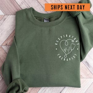 a green sweatshirt with a heart and a stethoscope on it