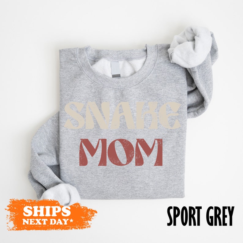 a gray shirt with a white ruffle sleeve and a slogan on it