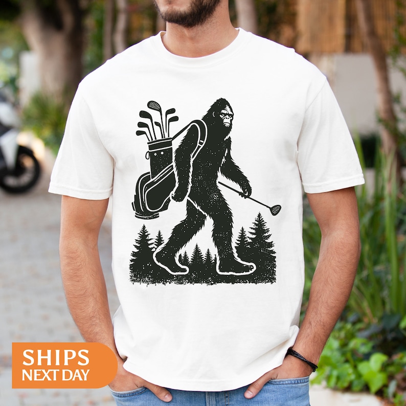 a man wearing a t - shirt with a bigfoot carrying a backpack