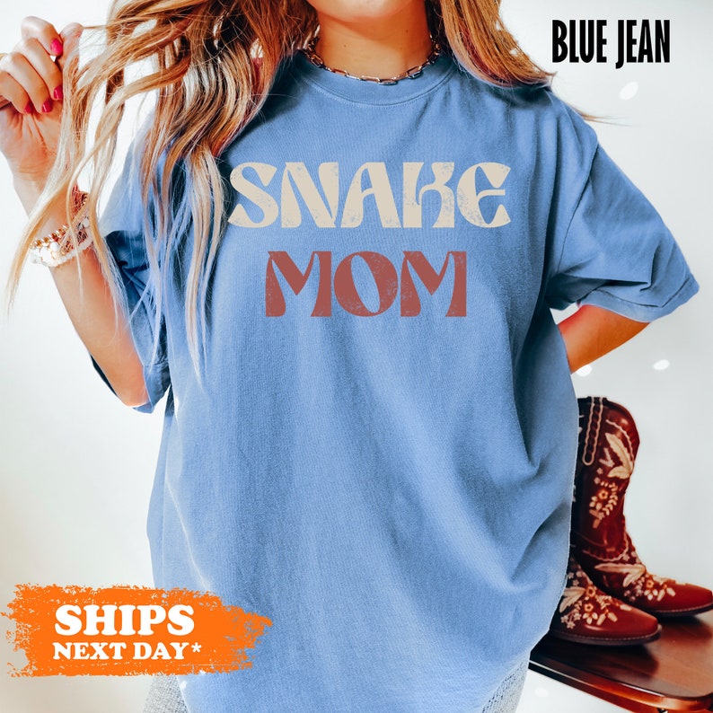 a woman wearing a blue shirt with the words snaag mom on it
