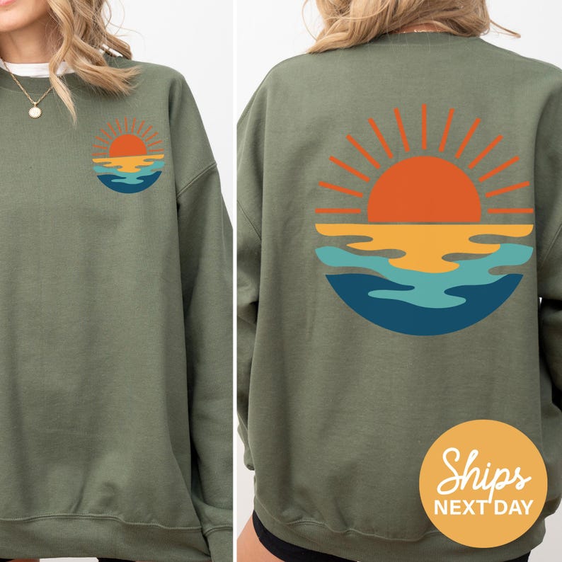 a woman wearing a sweatshirt with a sunset on it